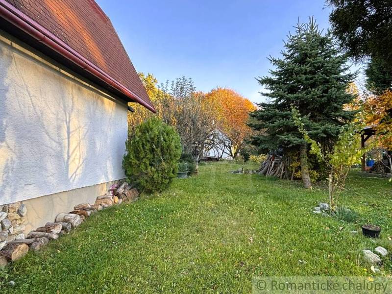 Herbst in Sološnica bei der Hütte, umgeben von Grün und Nadelbäumen.