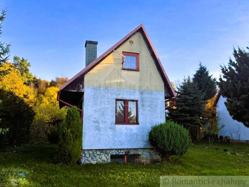 Eine Hütte in Sološnica, umgeben von Grün, mit blauer Putzfassade und schrägem Dach.