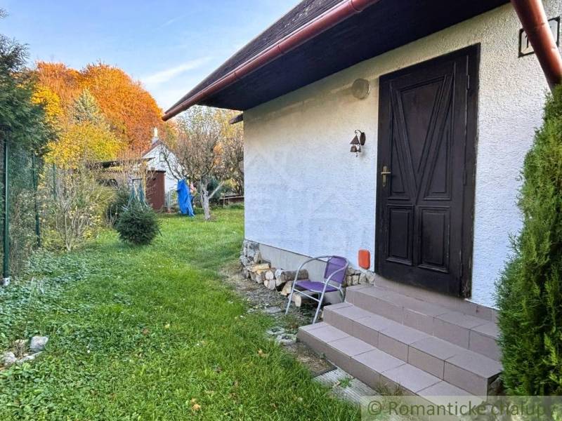 Ein Haus in Sološnica mit Rasen und Bäumen in einer farbenfrohen Herbstlandschaft.
