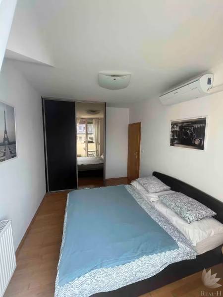 Schlafzimmer in einer 3-Zimmer-Wohnung mit Bett, Klimaanlage und Einbauschrank.