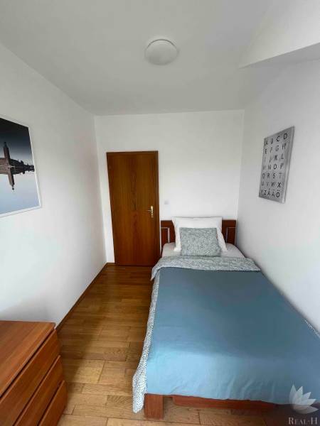 Einfaches Schlafzimmer mit Bett und Holzmöbeln in einer 3-Zimmer-Wohnung.