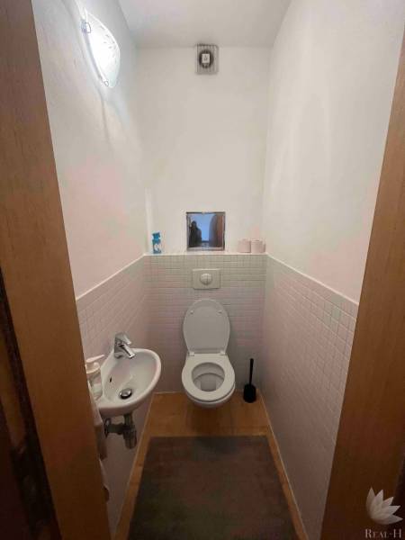 WC in einer 3-Zimmer-Wohnung mit Sanitäranlagen, Waschbecken und Fliesen.