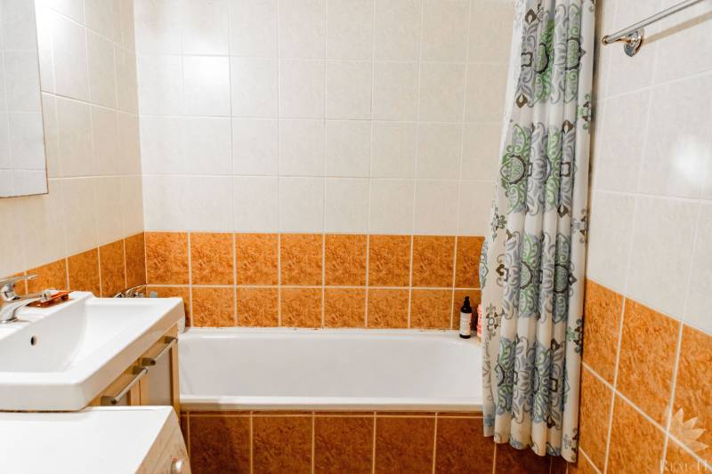 Badezimmer mit Badewanne und Keramikfliesen in einer 2-Zimmer-Wohnung.