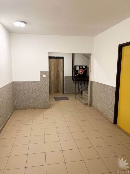 Eingangshalle mit Fliesen und Treppen in einem Wohngebäude.