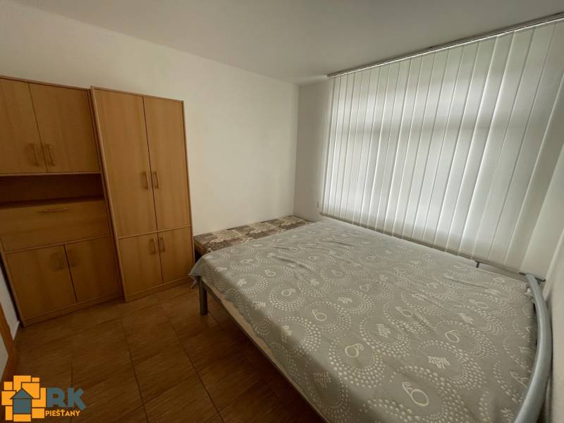 Schlafzimmer im Einfamilienhaus mit weißen Rollläden, Bett und Schränken.