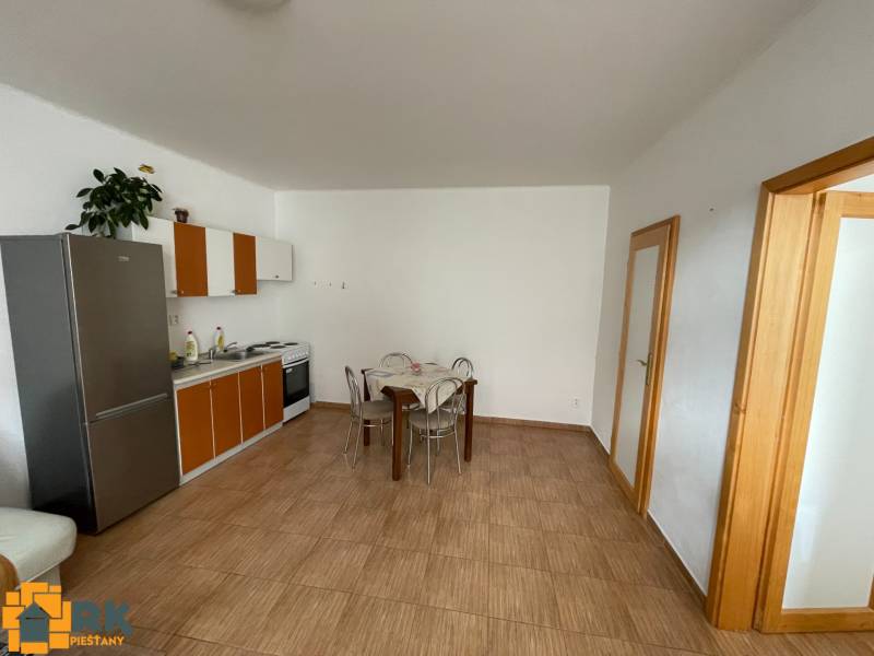 Küche in einem Einfamilienhaus mit Fliesenboden und Esstisch.