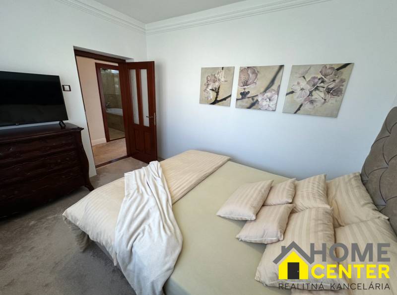 Schlafzimmer eines Einfamilienhauses mit dekorativen Bildern an der Wand, gepolsterten Möbeln und Türen.