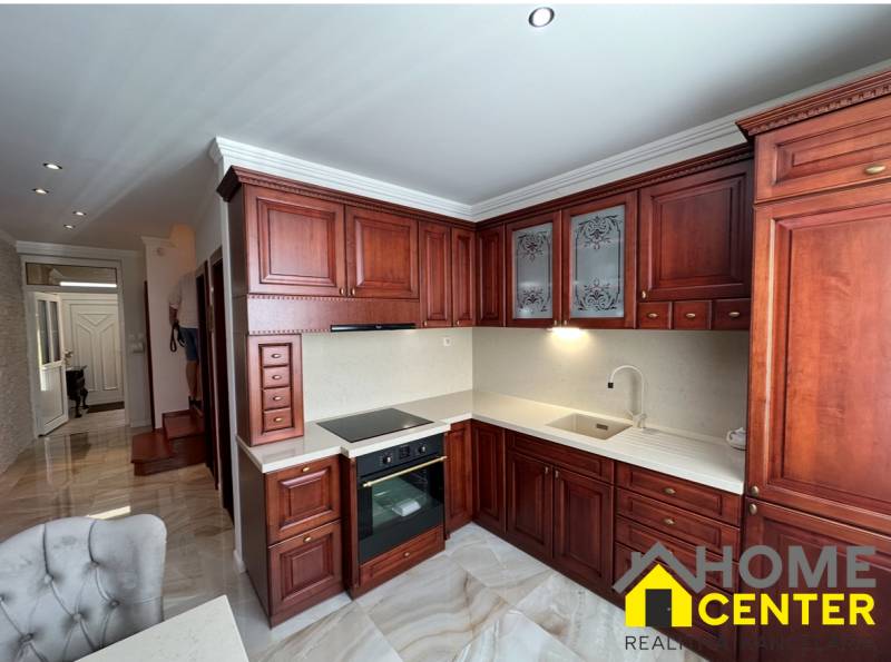 Küche mit dunklen Holzschränken und Holzboden in einem Einfamilienhaus.