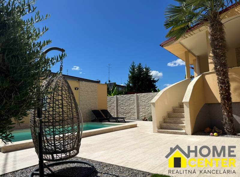 Einfamilienhaus in Komárno, Außenbereich mit Garten, Pool und Entspannungsecke.