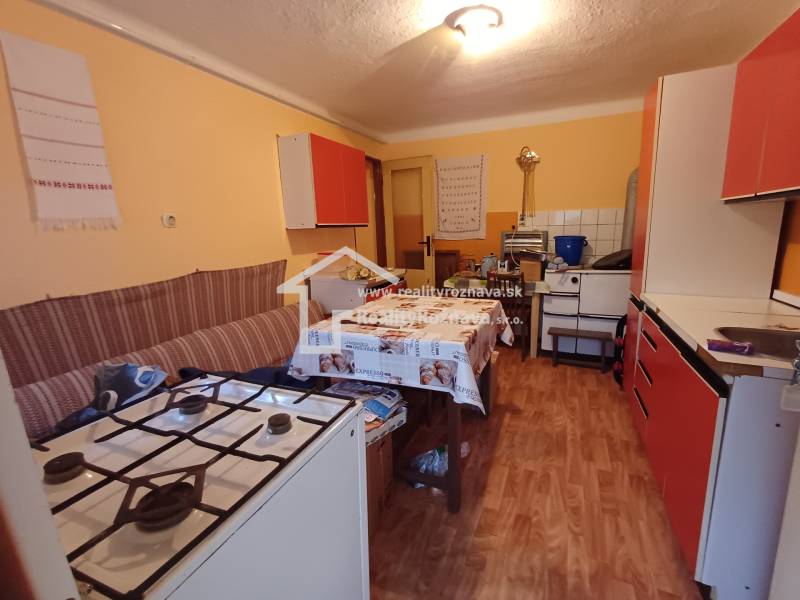 Eine Küche in einem Einfamilienhaus mit einem Gasherd und einem Boden in Holzoptik.