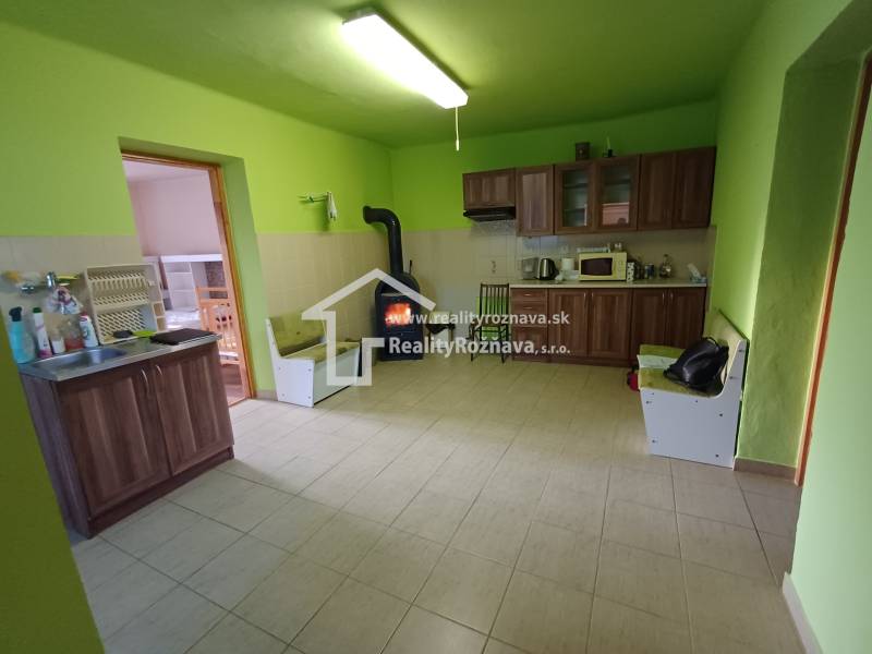 Küche in einem Einfamilienhaus mit Holzelementen, grüne Wände, Holzofen.