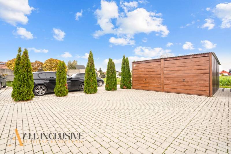 Parkplatz bei einer 3-Zimmer-Wohnung in Gabčíkovo, mit Autos und einer Holzgarge.