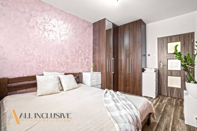 Schlafzimmer mit Bett, Schrank und Holzboden in einer 3-Zimmer-Wohnung.