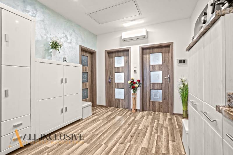 Innenraum einer 3-Zimmer-Wohnung mit Holzboden und weißen Möbeln.