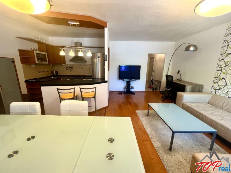 Wohnzimmer in einer 3-Zimmer-Wohnung mit Küche, Esstisch und bequemer Sitzgelegenheit.