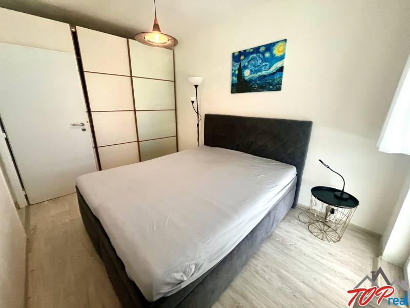 Schlafzimmer in einer 3-Zimmer-Wohnung mit Kleiderschrank und Nachttisch.