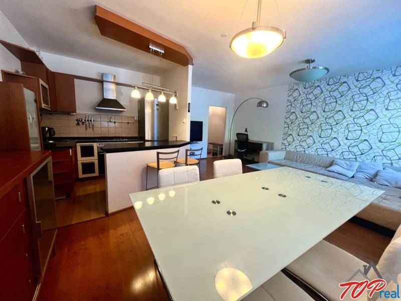 Küche und Wohnzimmer in einer 3-Zimmer-Wohnung mit modernen Möbeln und einer dekorativen Wand.