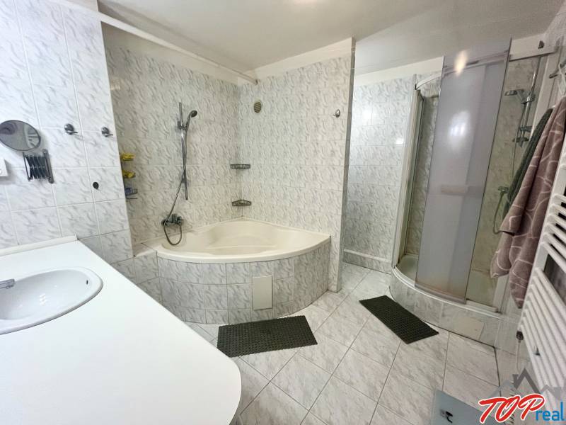 Badezimmer in einer 3-Zimmer-Wohnung mit Badewanne, Dusche und Waschbecken.