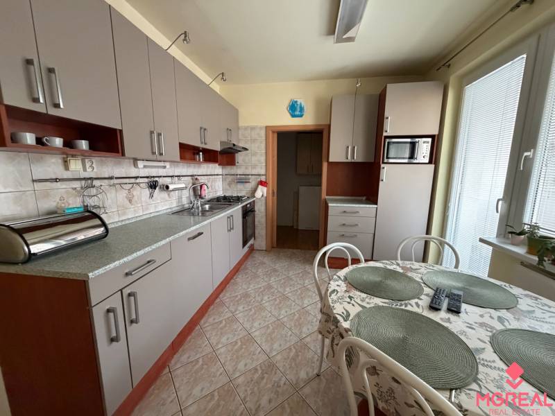 Eine Küche mit hellgrauen Schränken in einer 3-Zimmer-Wohnung, ergänzt durch einen Esstisch.