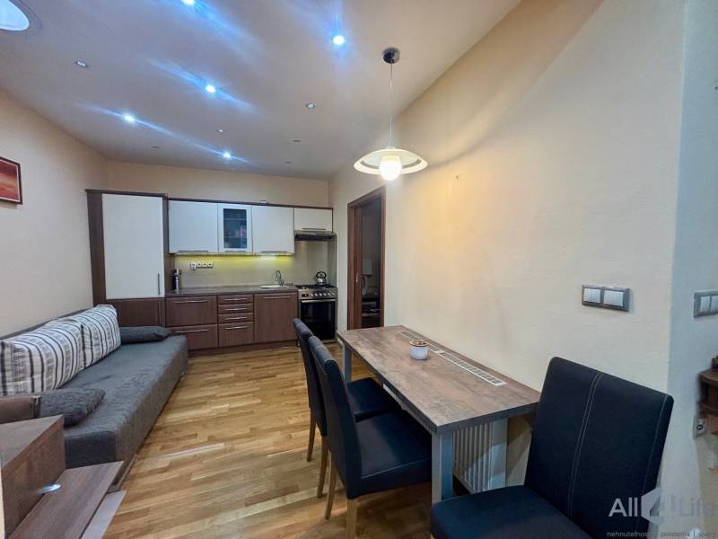 Küchenecke mit Essbereich in einer Einzimmerwohnung mit Holzboden.