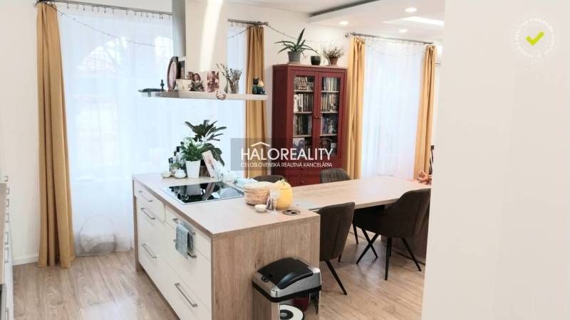 Moderne Küche in einer 3-Zimmer-Wohnung mit einer Insel und einem Boden in Holzoptik.