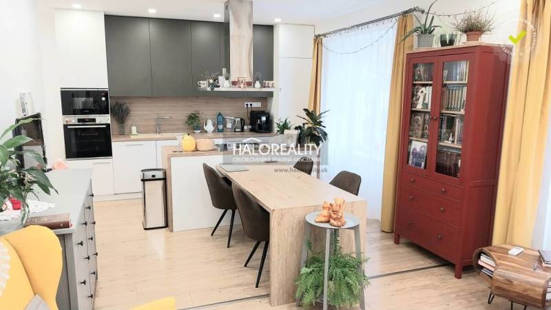 Innenraum einer Küche in einer 3-Zimmer-Wohnung mit Esstisch und Boden in Holzoptik.