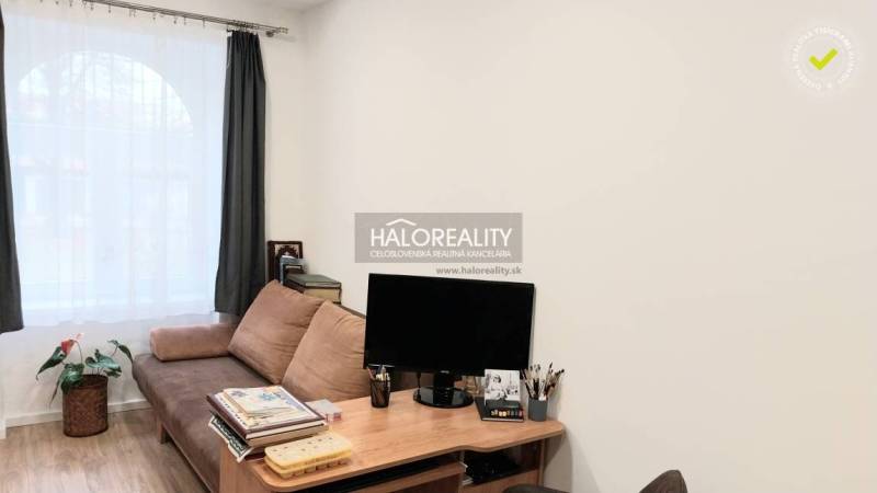 Wohnzimmer mit Sofa, Tisch und Holzboden in einer 3-Zimmer-Wohnung.