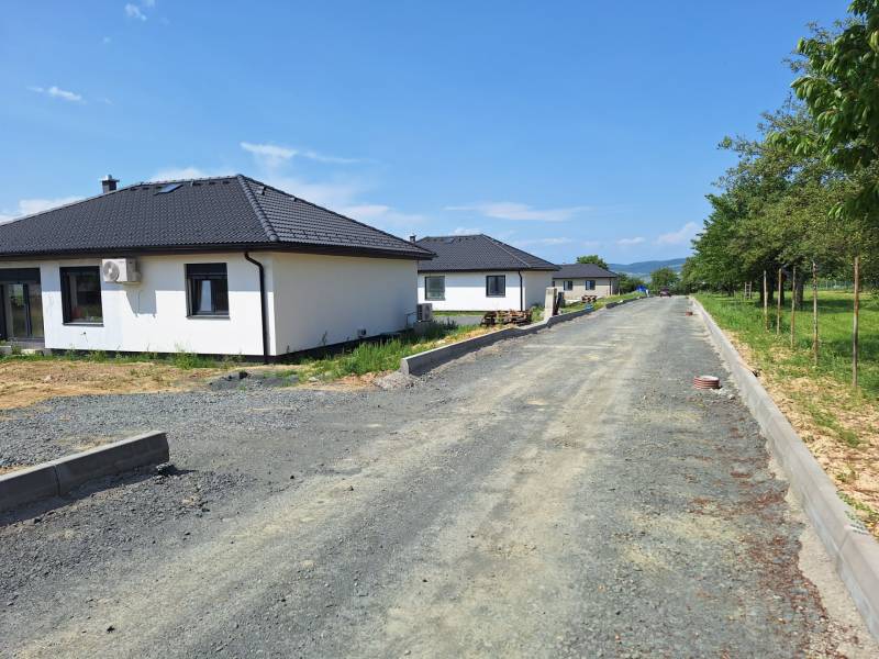 Einfamilienhäuser in der Straße Vyšná Šebastová in Prešov, umgeben von Grünflächen, neben einer unvollendeten Straße.