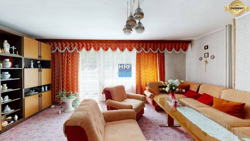 Wohnzimmer in einem Einfamilienhaus mit orangefarbenen Vorhängen und stilvoller Einrichtung.