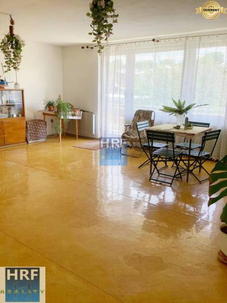 Ein geräumiges, helles Wohnzimmer, ein Boden mit Holzdekor, Möbel und Pflanzen in einem Einfamilienhaus.