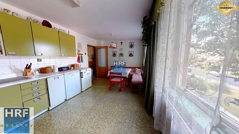 Eine Küche in einem Einfamilienhaus mit Retro-Möbeln, einem Tisch, einem großen Fenster und Dekorationen.