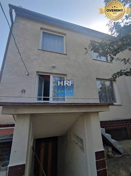 Ein Einfamilienhaus in Radošovce in Vieska mit einer Außentreppe und einer weißen Fassade.