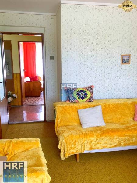 Wohnzimmer in einem Einfamilienhaus mit bunten Decken und Polsterungen auf den Sofas.