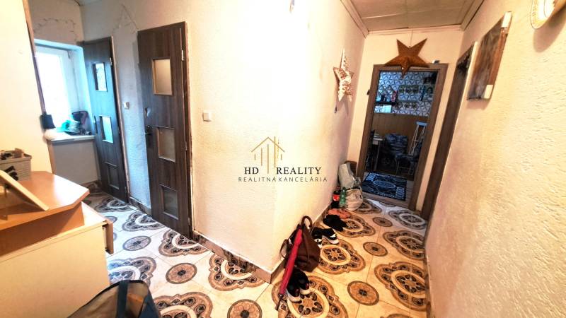 Flur in einer 2-Zimmer-Wohnung mit dekorativen Fliesen und Möbeln.