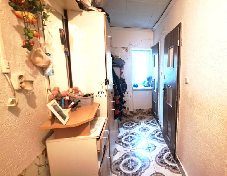 Flur mit Schränken und Dekorationen in einer Zweizimmerwohnung. Links Kleiderhaken, rechts Türen.