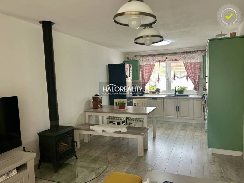 Innenraum eines Einfamilienhauses mit Küche, Esstisch und Kachelofen.