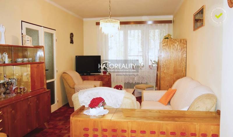 Wohnzimmer in einer 3-Zimmer-Wohnung, Boden mit Holzdekor, Holzmöbel, gemütliche Sessel.