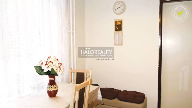 Essbereich in einer 3-Zimmer-Wohnung mit einer Blume auf dem Tisch und einem weißen Vorhang.