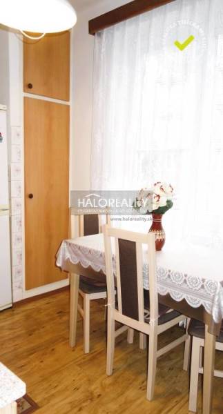 Esszimmer in einer 3-Zimmer-Wohnung mit Holzboden und hellen Vorhängen.