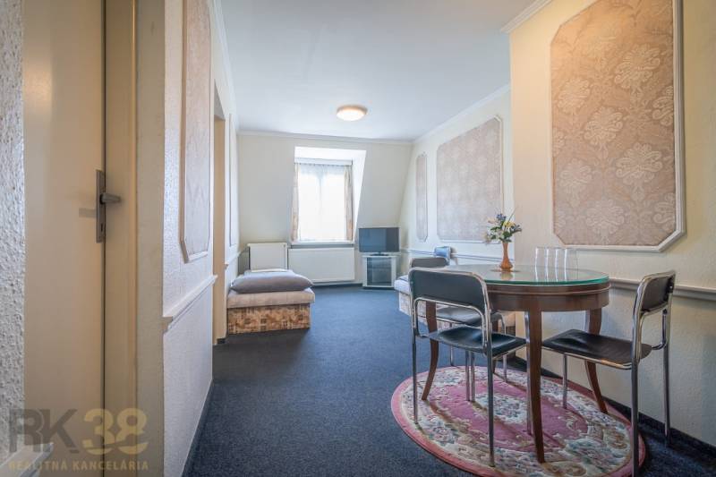 Ein Zimmer in Hotels und Pensionen mit einem runden Tisch und einem Fernseher auf einem Ständer.