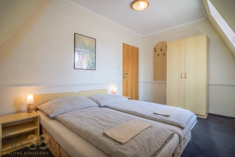 Doppelzimmer mit Bett, Nachttischen und Schrank in Hotels und Pensionen.