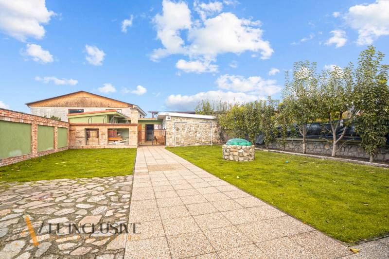 Der Garten beim Einfamilienhaus in der Kúpeľná-Straße in Dunajská Streda mit Rasen und Pflastersteinen.