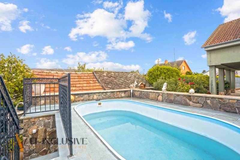 Schwimmbad und Steinzaun bei einem Einfamilienhaus in der Kúpeľná-Straße in Dunajská Streda.