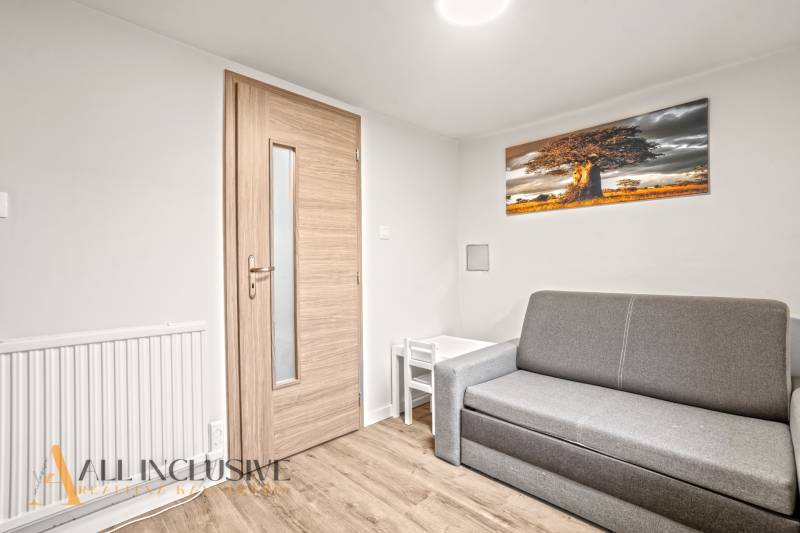 Wohnzimmer in einem Einfamilienhaus mit Sofa, Tisch und Holzboden.