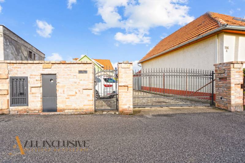 Ein Einfamilienhaus in der Kúpeľná-Straße in Dunajská Streda mit einem Tor und einem gepflasterten Hof.