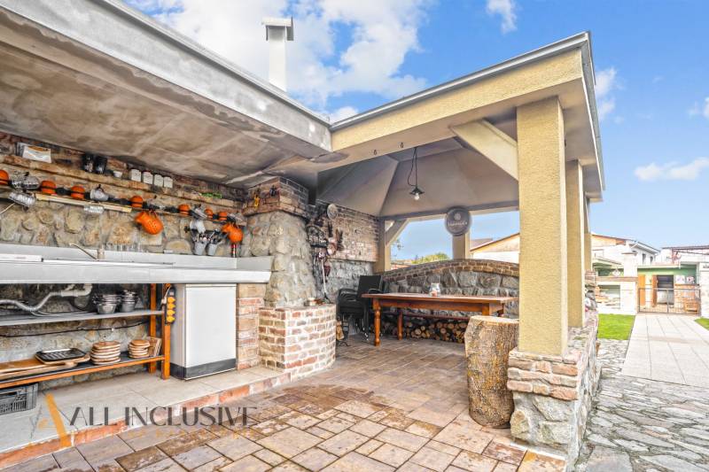 Exterieur eines Einfamilienhauses in der Kúpeľná-Straße in Dunajská Streda, Außenküche mit Sitzgelegenheit.