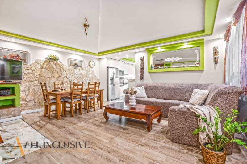 Wohnzimmer in einem Einfamilienhaus mit Steinwand und Boden in Holzoptik.