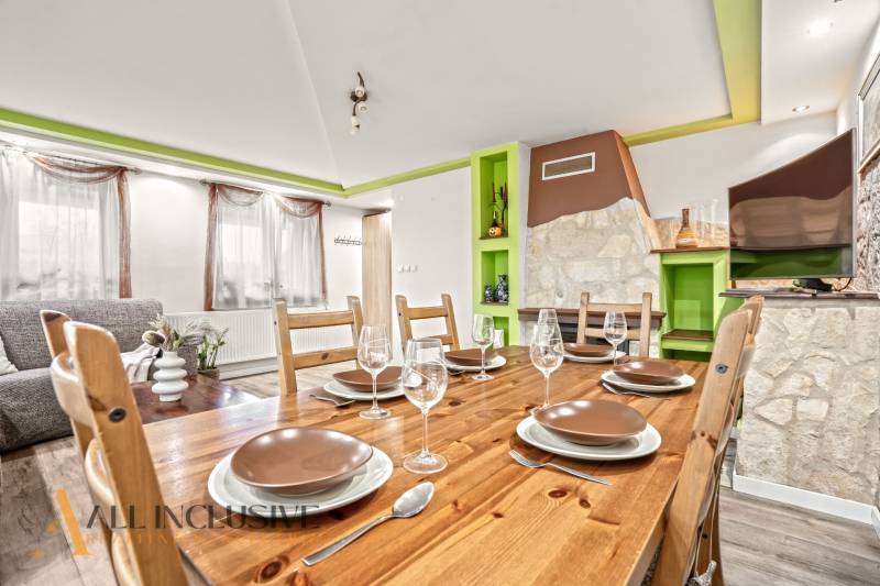 Esszimmer in einem Einfamilienhaus mit Holztisch, Gläsern und dekorativem Kamin.