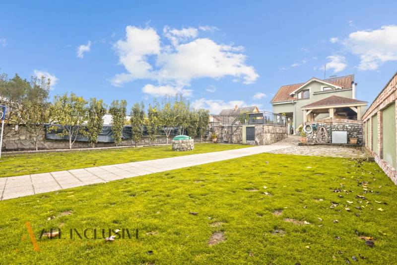 Der Garten des Einfamilienhauses in der Kúpeľná-Straße in Dunajská Streda mit gepflegtem Rasen und Bäumen.