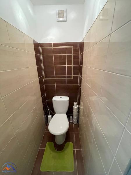Badezimmerteil einer Einzimmerwohnung mit stilvollen Fliesen und Toilette.
